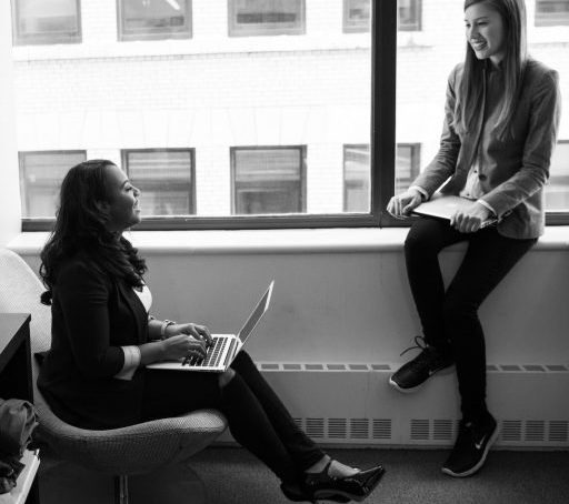 Woman in black work heels working on laptop and chatting